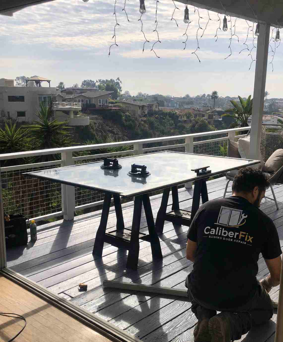 CaliberFix technician repairing a sliding door track on a patio deck