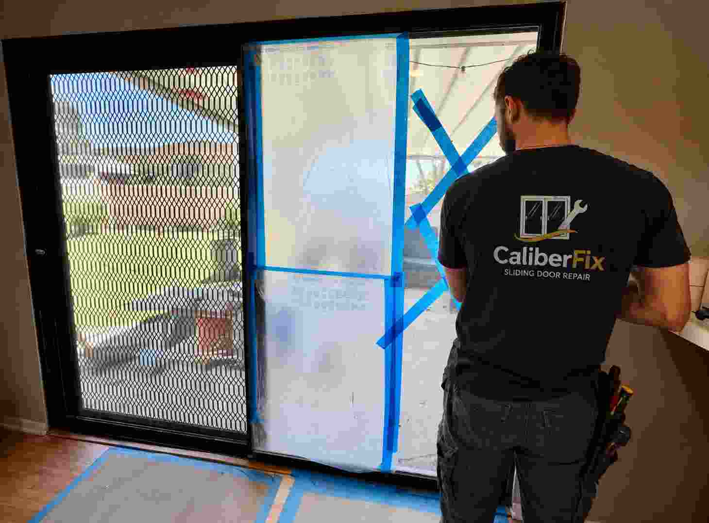 CaliberFix technician prepping a sliding glass door panel for repair — Jacksonville, FL